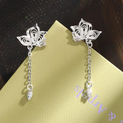 Silver butterfly stud earrings featuring dangling chains and teardrop charms