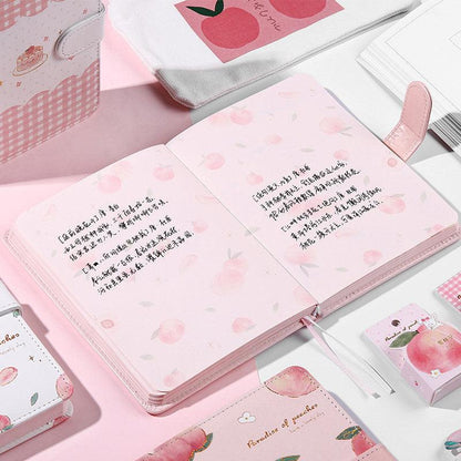 Opened pink notebook with peach-pattern pages and cursive text lines across the sheets