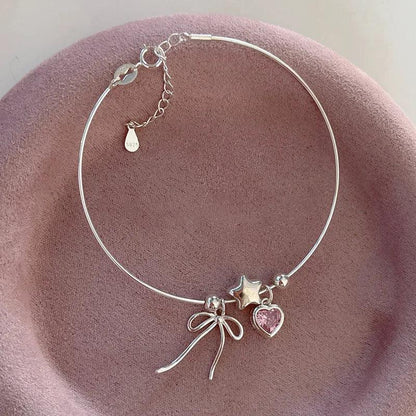 Silver bracelet with star, heart and bow charms, pink heart accents and clasp