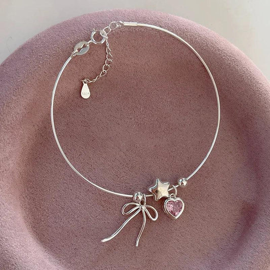 Silver bracelet with star, heart and bow charms, pink heart accents and clasp