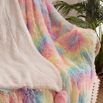 Pastel rainbow fluffy blanket detail with fuzzy sherpa underside and pom-pom corner