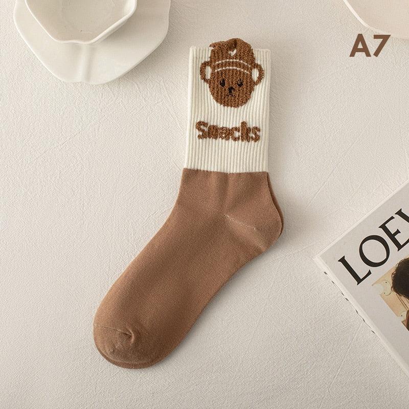 Two-tone tan and cream socks with teddy bear head on the cuff and stitched text