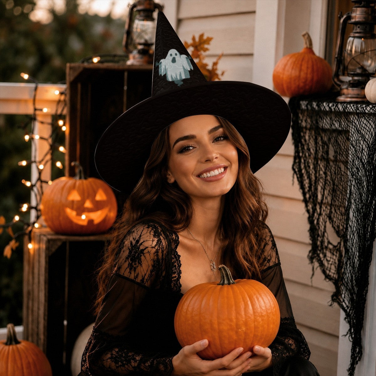 Black witch hat with ghost patch and wide brim, worn while holding a pumpkin
