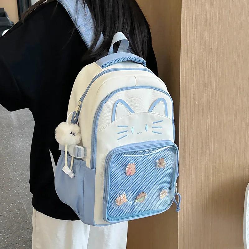 White cat school backpack with blue-trim mesh pocket; shown from side with shoulder straps.