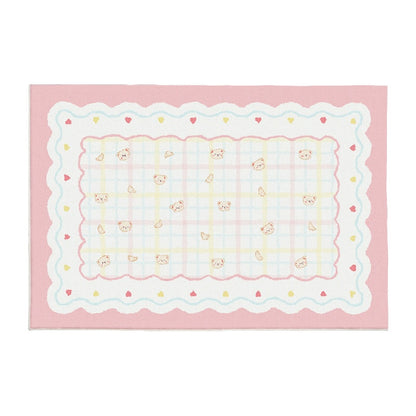 Pink plush area rug with scalloped border, light checker grid, and small bunny faces