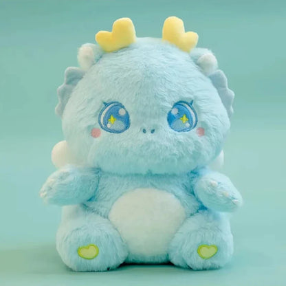 Light blue baby dragon plush with blue star-eye patches and yellow horn tips