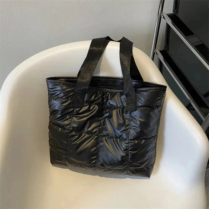 Black quilted cotton tote bag with long handles and top opening, textured padded front