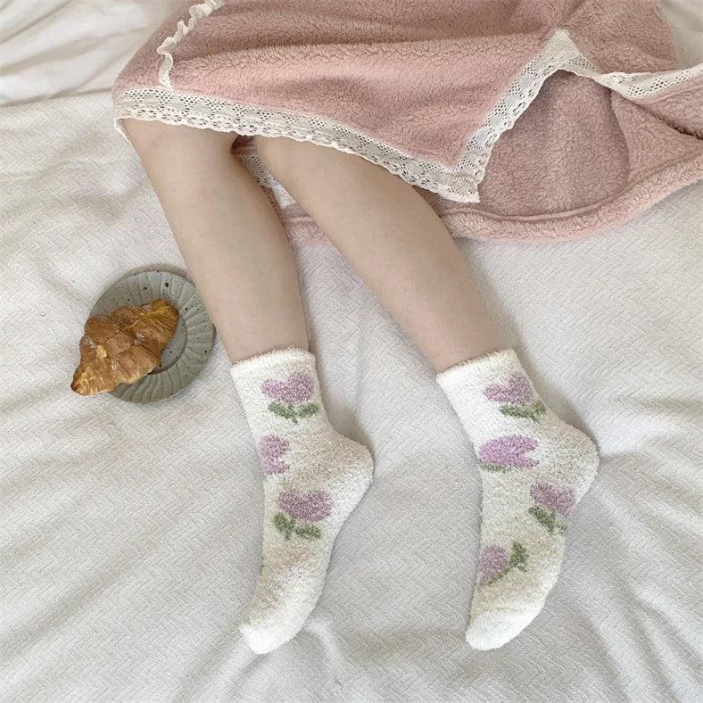 Plush sleeping socks on legs, white with purple and green berry-style prints