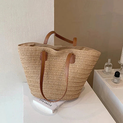 Large woven straw tote bag with brown faux-leather handles and top lining