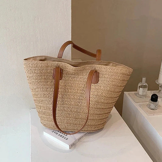 Large woven straw tote bag with brown faux-leather handles and top lining