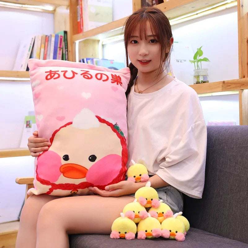 Pink duck pillow with large duck face graphic and a pile of small duck plushies