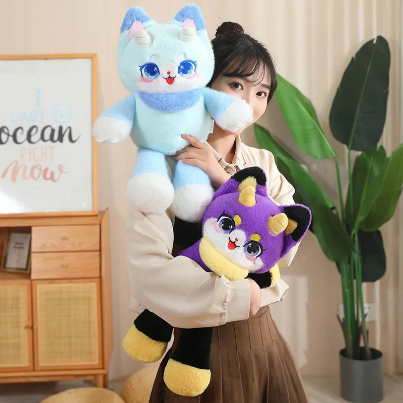 Light blue dragon cat plush and purple dragon cat plush, held together by a person