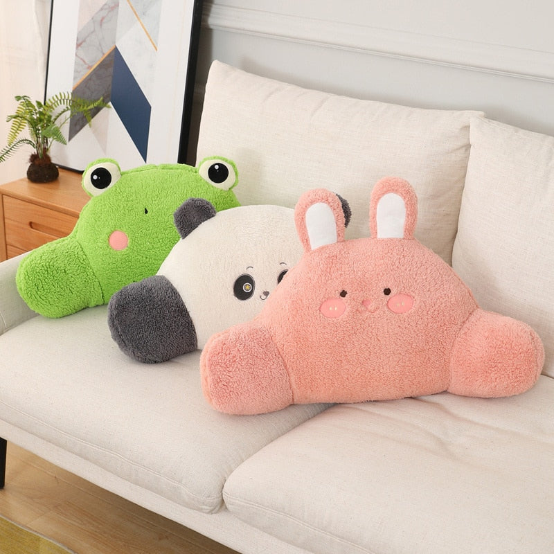 Plush animal cushions on a sofa: green frog, panda, and pink bunny pillows.