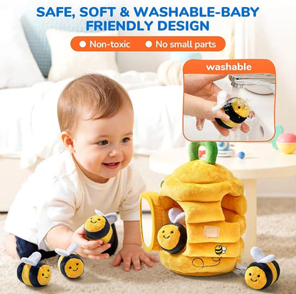 Plush yellow beehive sensory toy with smiling bee faces, soft white wings, and wash-ready design