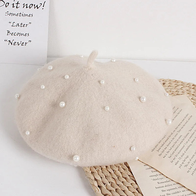 Beige felt beret with faux pearl embellishments and a small center stem