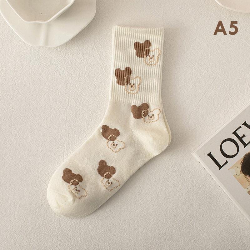 Cream teddy bear print socks with three brown bear faces and small bear accents