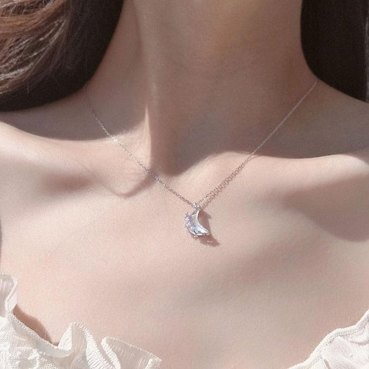 Moon pendant necklace with blue glazed crescent charm and crystal details on silver chain