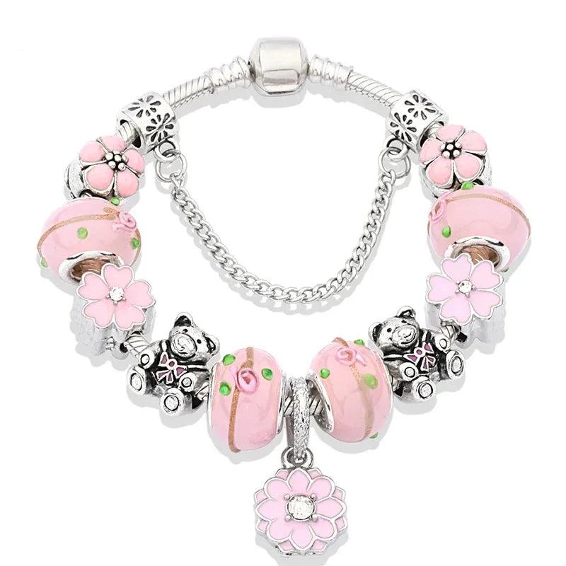 Silver charm bracelet with pink enamel cat and flower charms, glass bead center, clasp