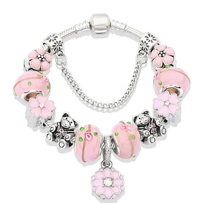 Silver charm bracelet with pink enamel cat and flower charms, glass bead center, clasp