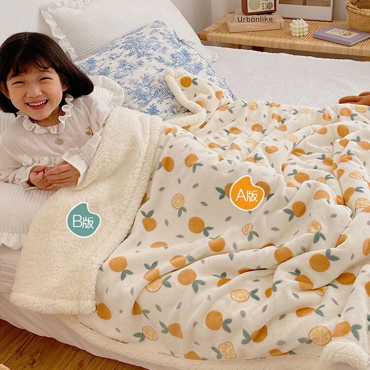 White lamb fleece blanket with orange fruit and leaf pattern, plush sherpa border.