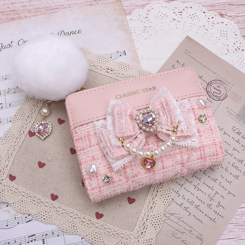 Pink quilted wallet with bow and heart charms, pearl trim, and gold-tone zipper