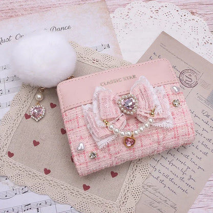 Pink quilted wallet with bow and heart charms, pearl trim, and gold-tone zipper