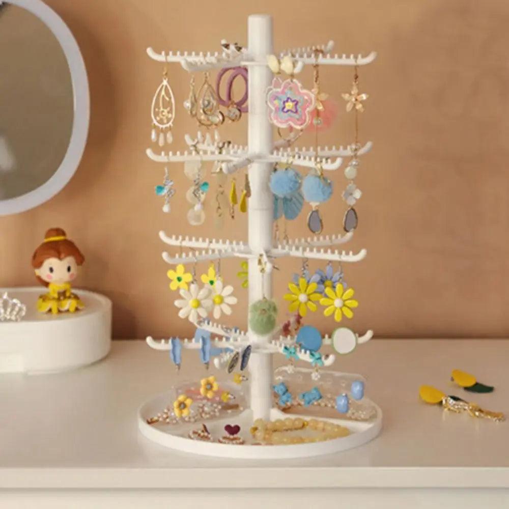 White rotating earring display stand with curved hook arms and colorful earrings