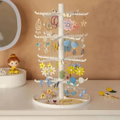 White rotating earring display stand with curved hook arms and colorful earrings
