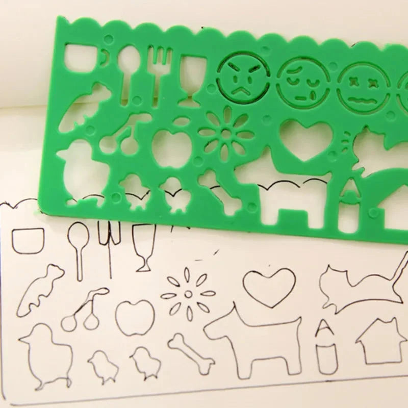 Green plastic stencil with dinosaur and heart icon cutouts over outline sheet