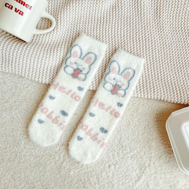 Bunny socks with white fuzzy fabric, blue bunny face graphic, and pastel heart motifs.