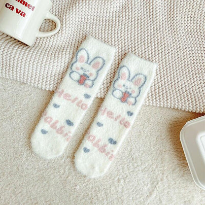 Bunny socks with white fuzzy fabric, blue bunny face graphic, and pastel heart motifs.