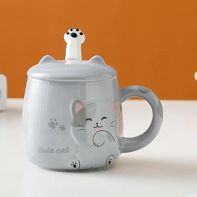 Light gray cat face lidded mug with paw prints, standing on a flat surface