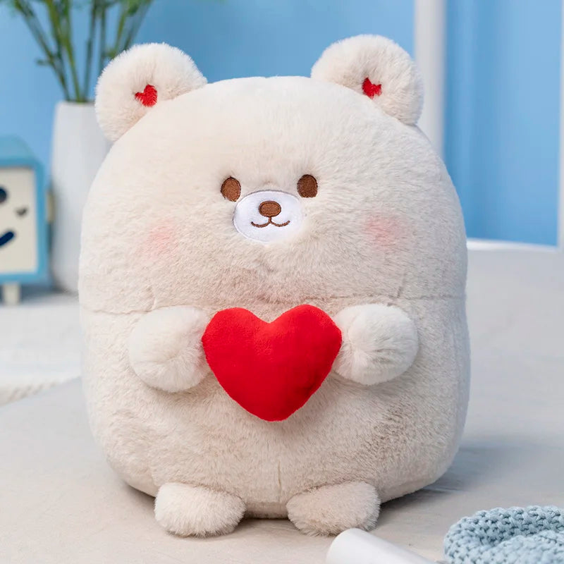 Cream bear plush with red heart on its chest, sitting.