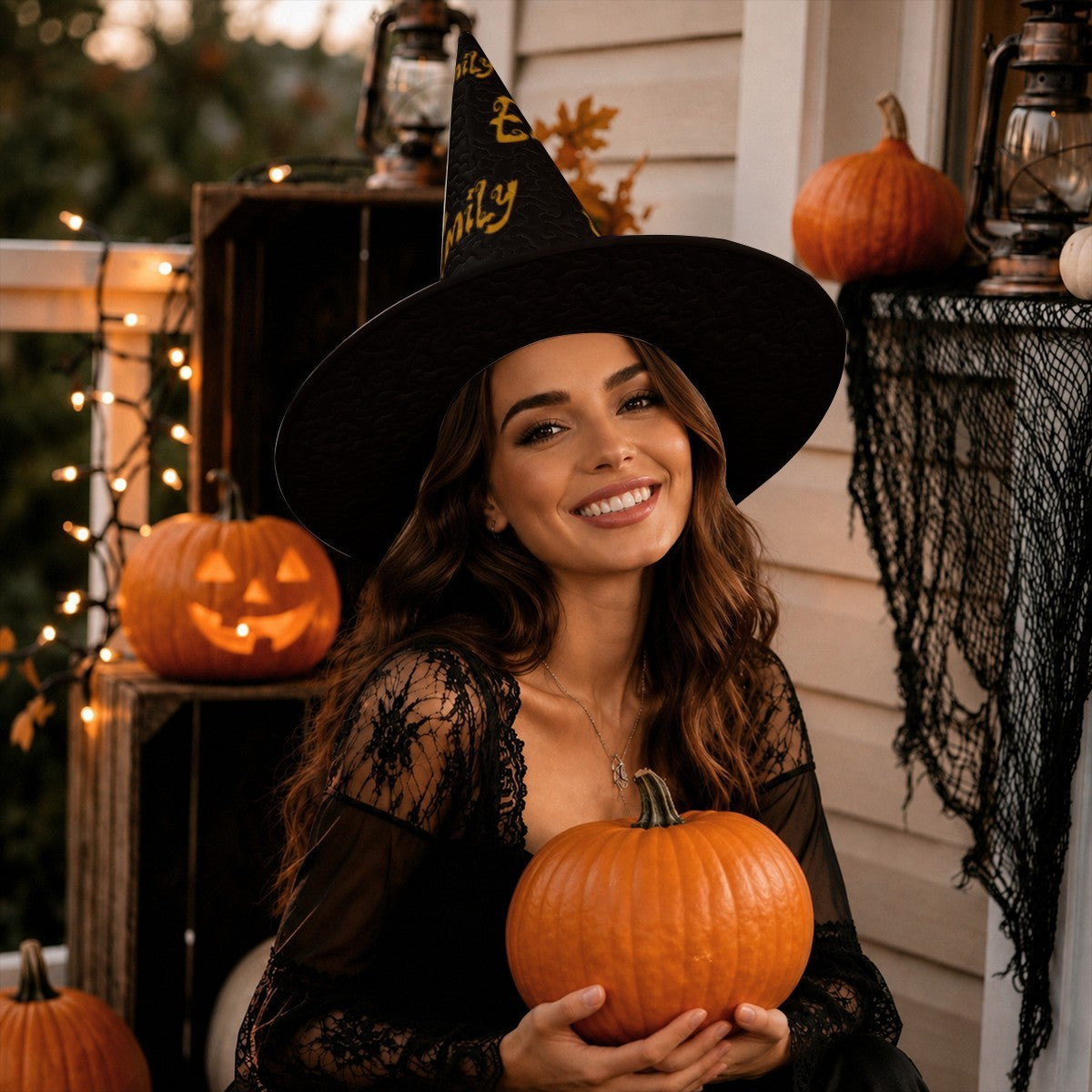 Black pointed witch hat with gold “Emily” writing, worn by a woman holding a pumpkin