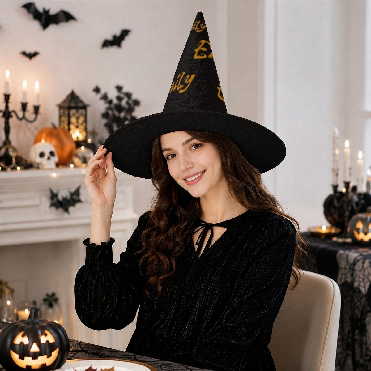 Black witch hat with wide brim and gold “Emily” lettering, worn by a smiling woman