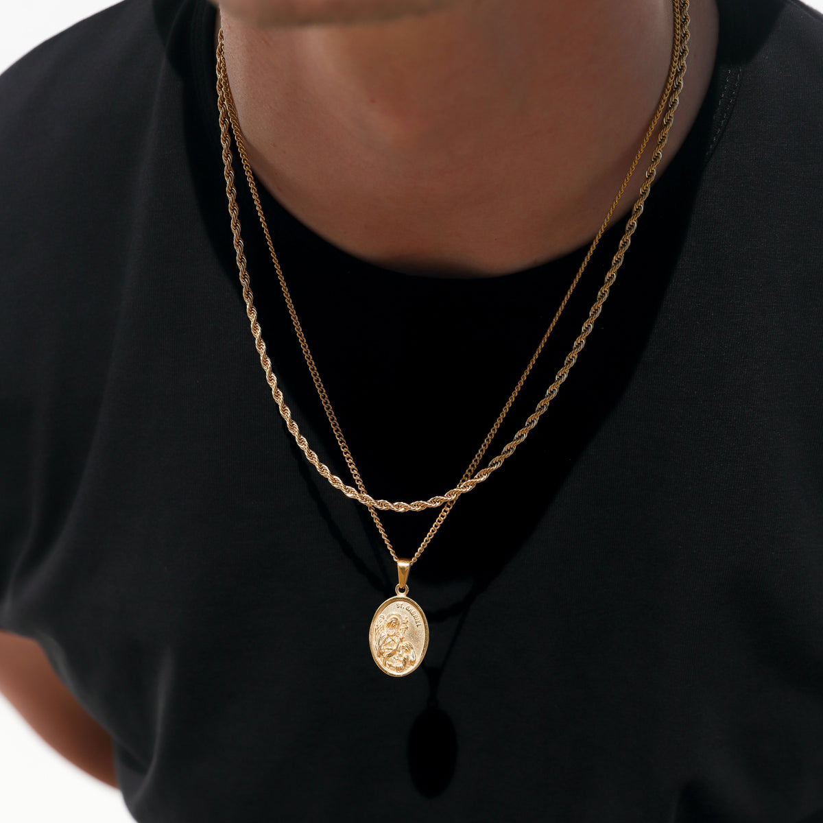 Gold oval pendant on layered chain necklace