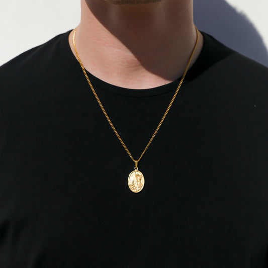 Gold Saint Raphael medallion pendant necklace on a model’s neck, black shirt