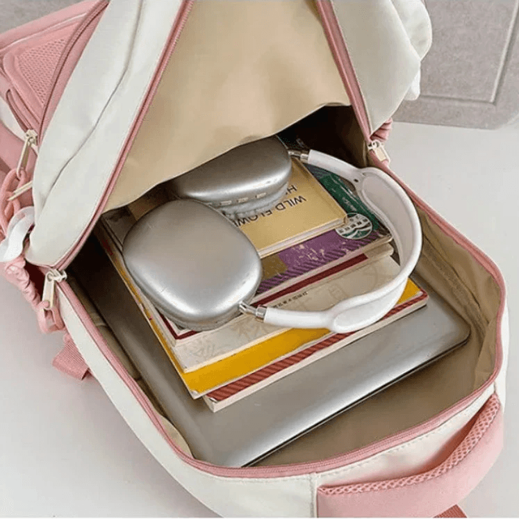 Pink mini cat-ear backpack open showing mesh front pocket and items inside