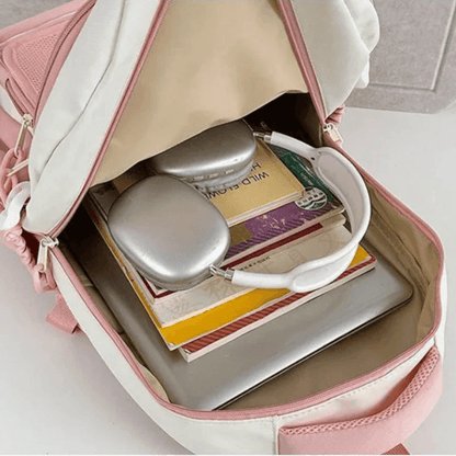 Pink mini cat-ear backpack open showing mesh front pocket and items inside