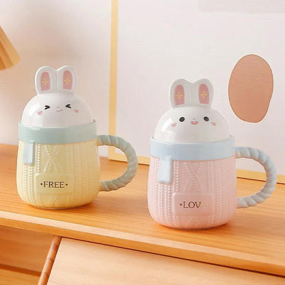 Bunny ceramic mug set with pink and blue bodies, rabbit lids, and 'LOVE'/'FREE' text.