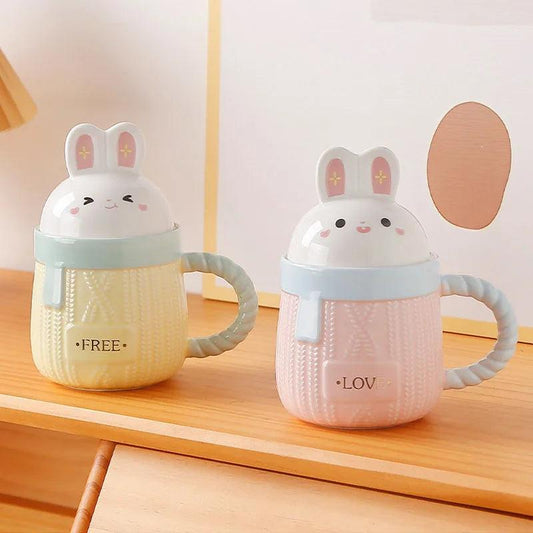 Bunny ceramic mug set with pink and blue bodies, rabbit lids, and 'LOVE'/'FREE' text.