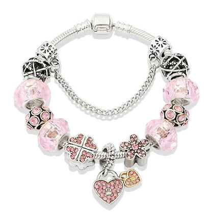 Pink bead charm bracelet with silver cross, heart, and bow charms