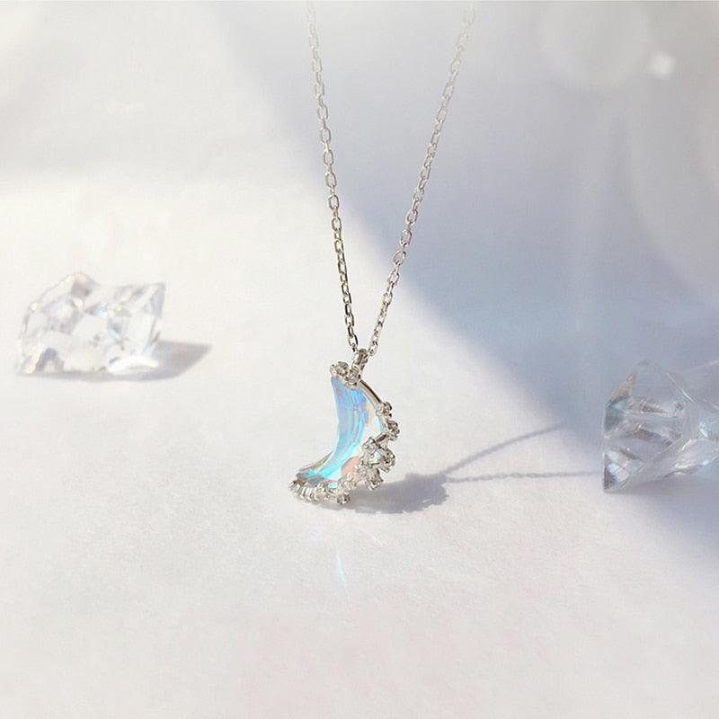 Crescent moon pendant necklace with blue iridescent glazed stone and crystal star embellishments