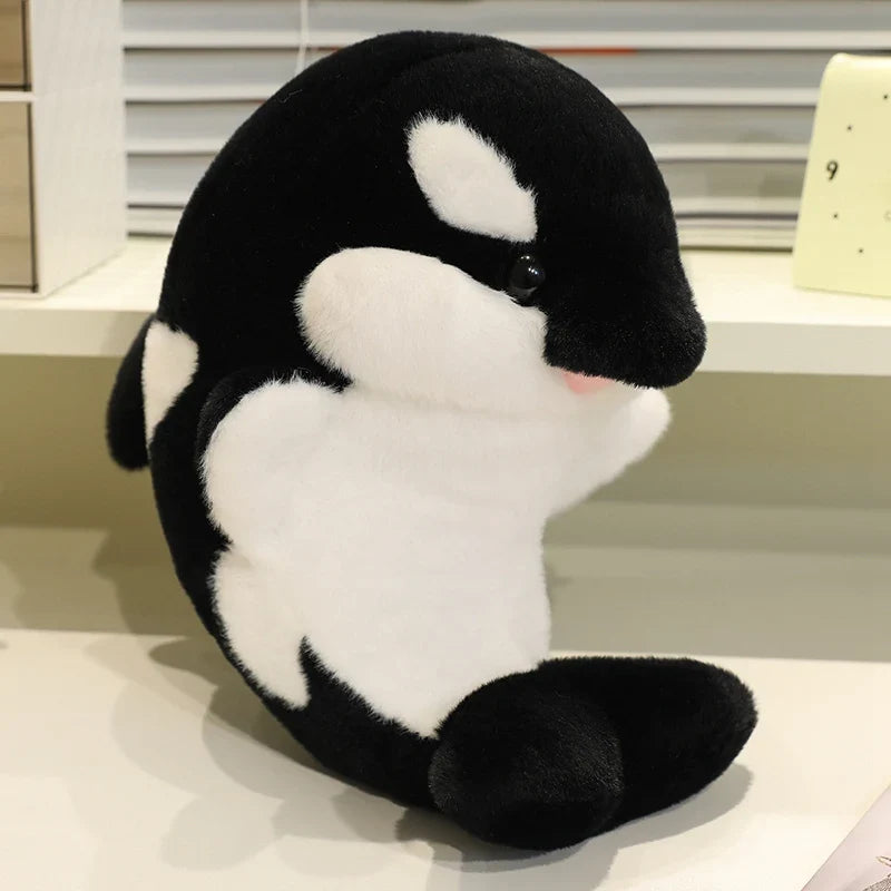 Black dolphin plush with white belly patch, curved body, embroidered eye and muzzle