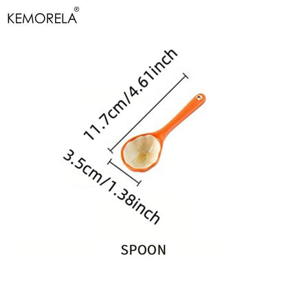 Orange ceramic spoon accessory with shallow bowl, pumpkin-style handle