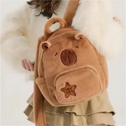 Tan capybara plush backpack with front zip pocket and rounded ears logo patch