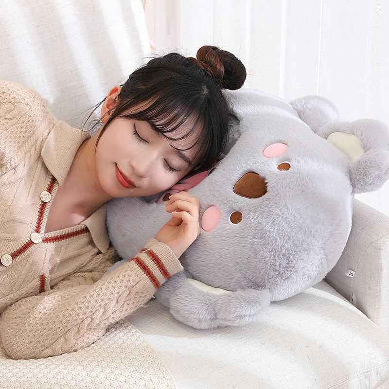 Light gray plush animal pillow with bear-like face, rounded ears, and brown nose