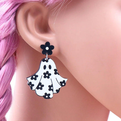 Ghost dangle earrings on ear with black flower top and white floral ghost charm