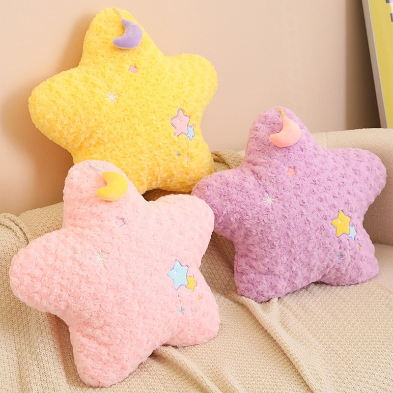 Pink, yellow, and purple star plush pillows with crescent moon details and stitched stars