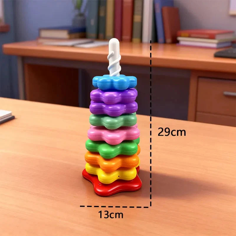 Rainbow rotating stacking tower toy with colorful discs on a white pole base on a table